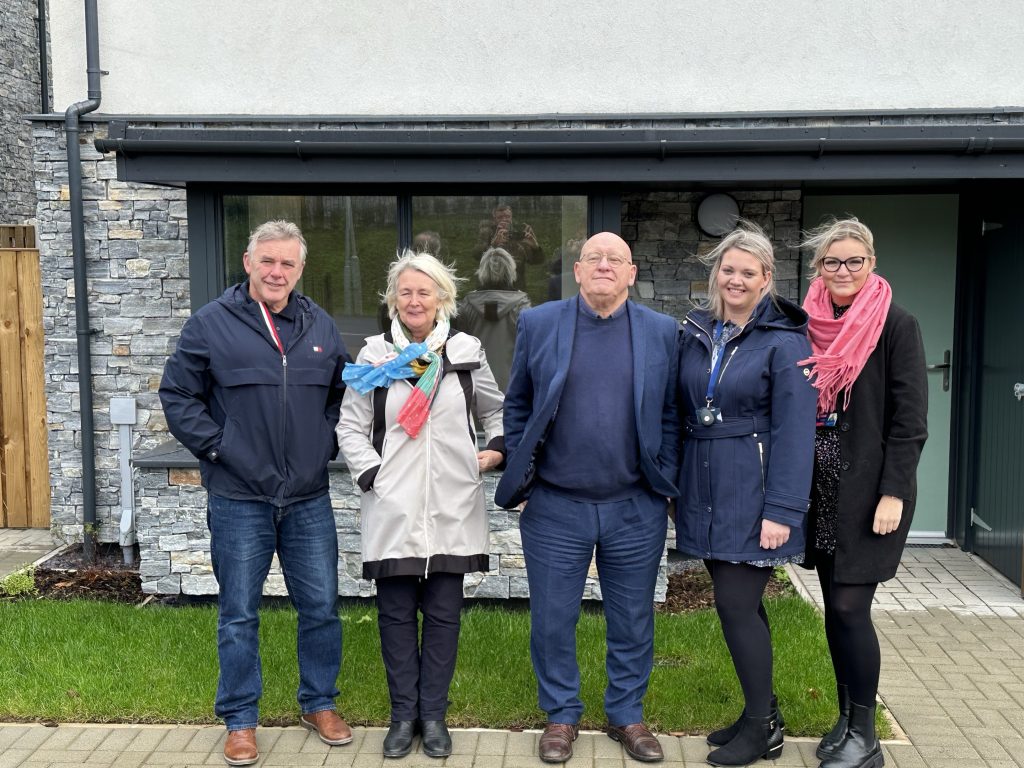 Picture of Iwan Trefor Jones, Siân Gwenllian, Hywel Williams, Gemma Owen and Elin Owen outside one of the houses in Cae Rhosydd